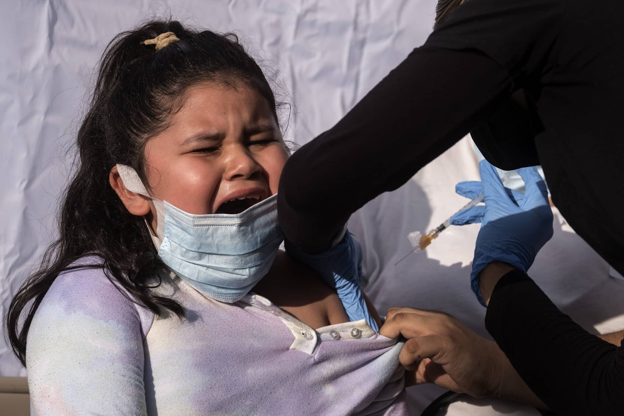 Una niña llora mientras recibe la vacuna del Covid en Los Ángeles.