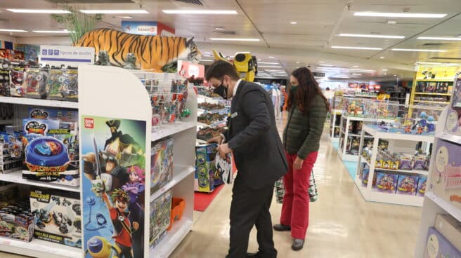 Varias personas observan los juguetes colocados en las estanterías de las instalaciones del Corte Inglés Preciados, en Madrid.