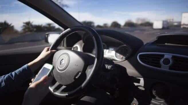 El Congreso debate una ley que evitará archivar imprudencias al volante con víctimas Conductor con un móvil al volante