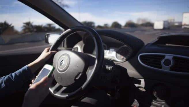 Conductor con un móvil al volante