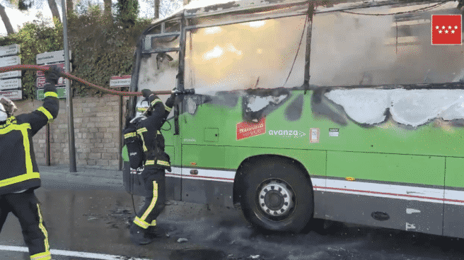 Arde completamente un autobús de transporte regular sin provocar heridos en el casco urbano de Pozuelo Autobús del casco urbano de Pozuelo incendiado, mientras lo bomberos intentan frenar el fuego
