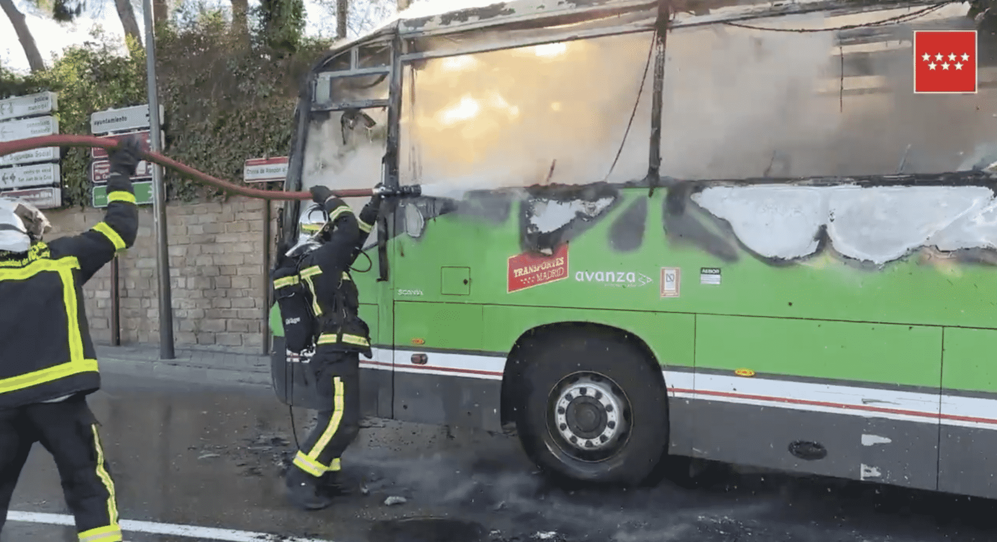 Autobús del casco urbano de Pozuelo incendiado, mientras lo bomberos intentan frenar el fuego