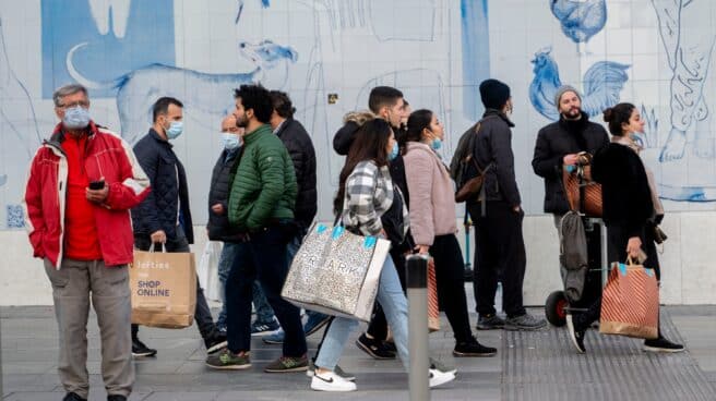 El repunte del virus y la crisis de suministros frenarán el gasto de los españoles hasta mitad de 2023 Varias personas caminan con bolsas con compras en Madrid.