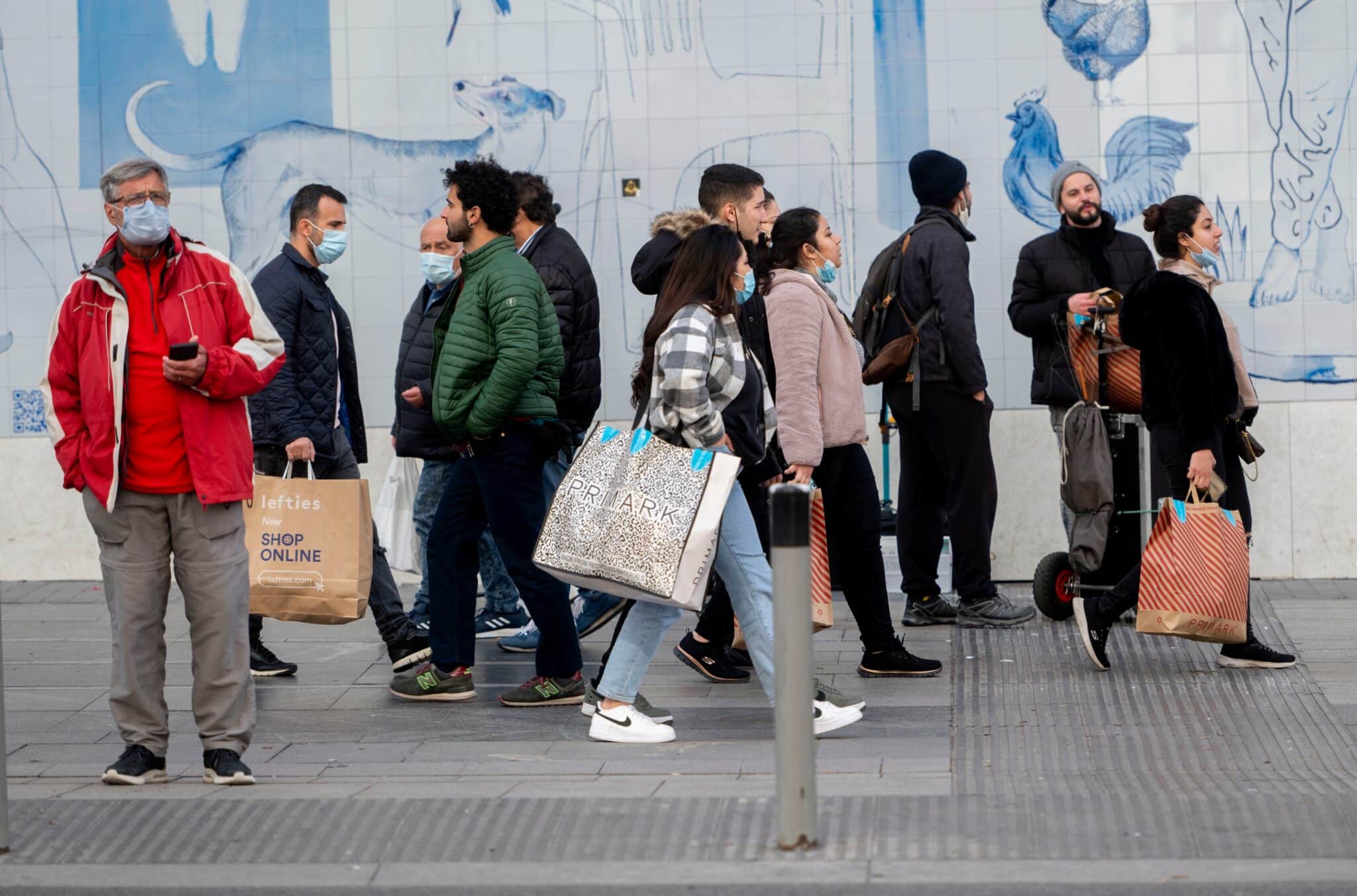 Varias personas caminan con bolsas con compras en Madrid.