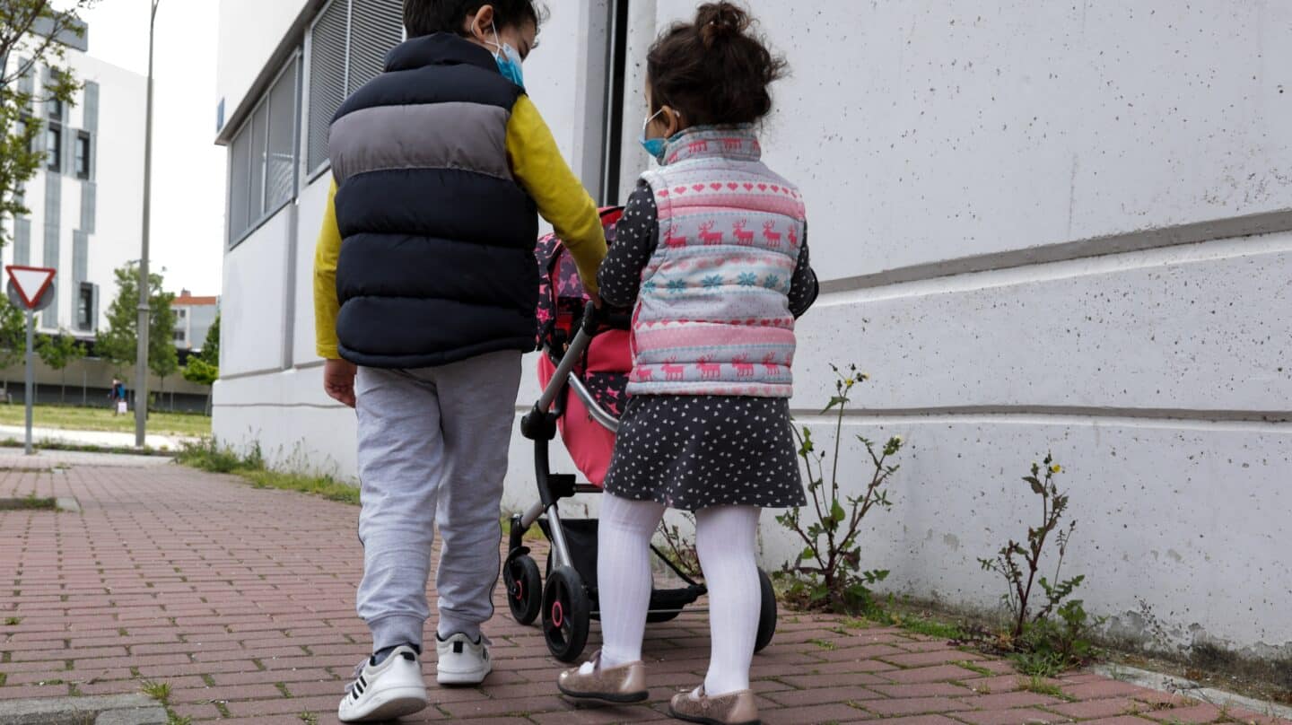 Dos niños pasean por la calle tras el confinamiento domiciliario de la primera ola del Covid, en abril de 2020.