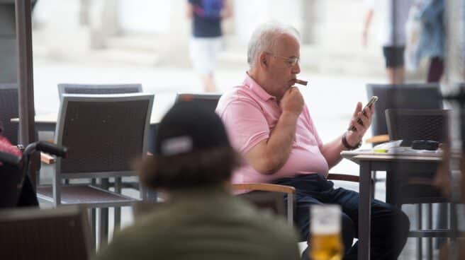 Un hombre fuma un puro en una terraza de Lugo.