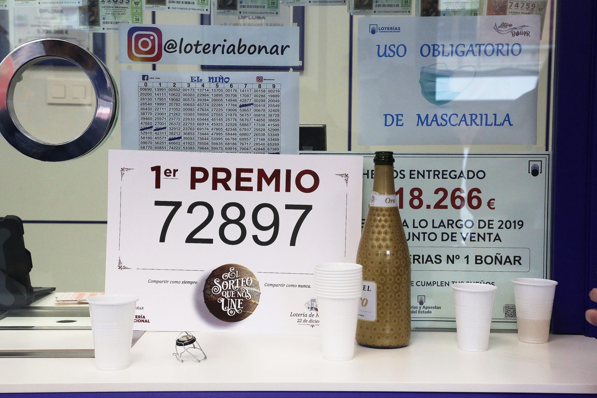 El premio `Gordo´ de la Lotería de Navidad junto a una botella de champán en la administración de lotería situada en la avenida de la Constitución, 52