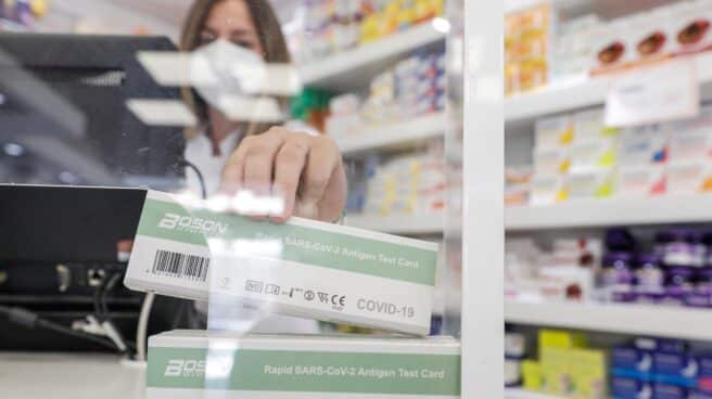 una farmacéutica muestra un test de antígeno de farmacia