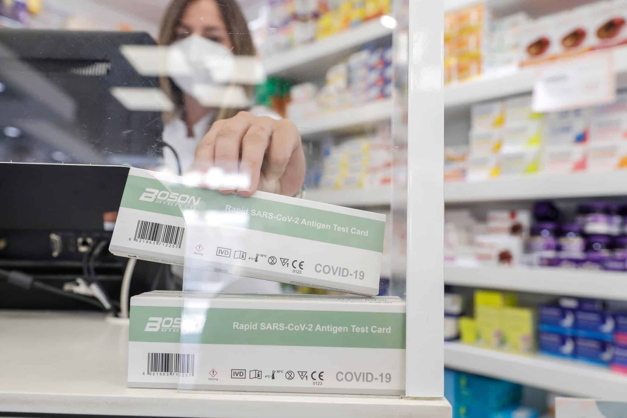 una farmacéutica muestra un test de antígeno de farmacia