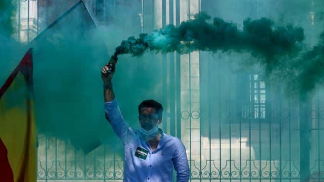 Un hombre lanza humo de color verde en una manifestación convocada por Solidaridad, el sindicato adscrito a Vox.