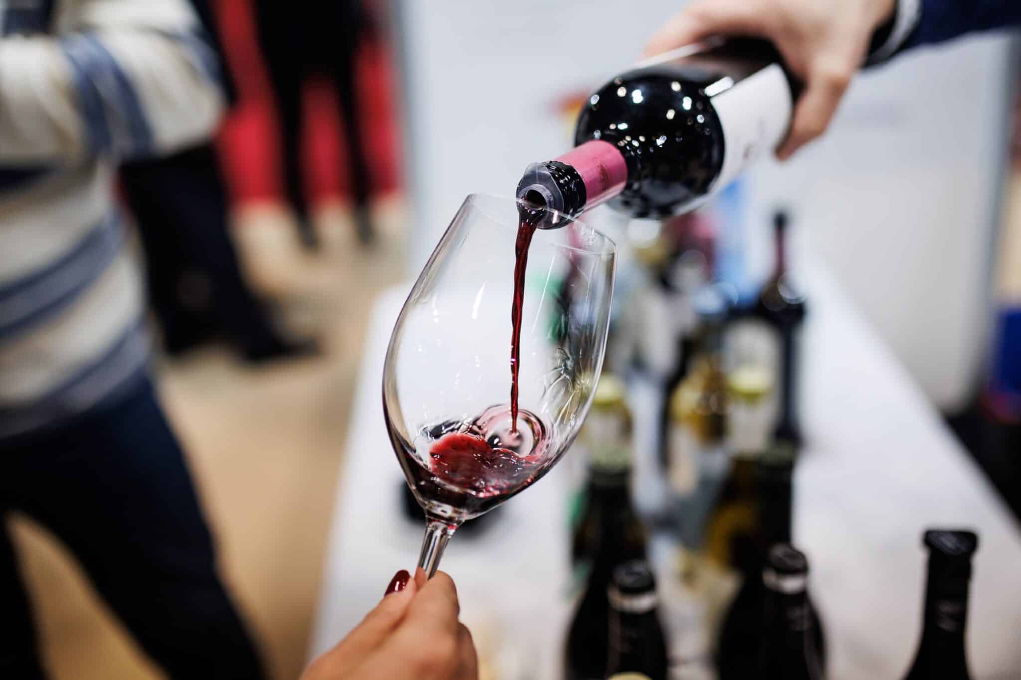 Una persona sirve una copa de vino en la inauguración del XXI Salón de los Mejores Vinos de España en el Pabellón 5 de IFEMA