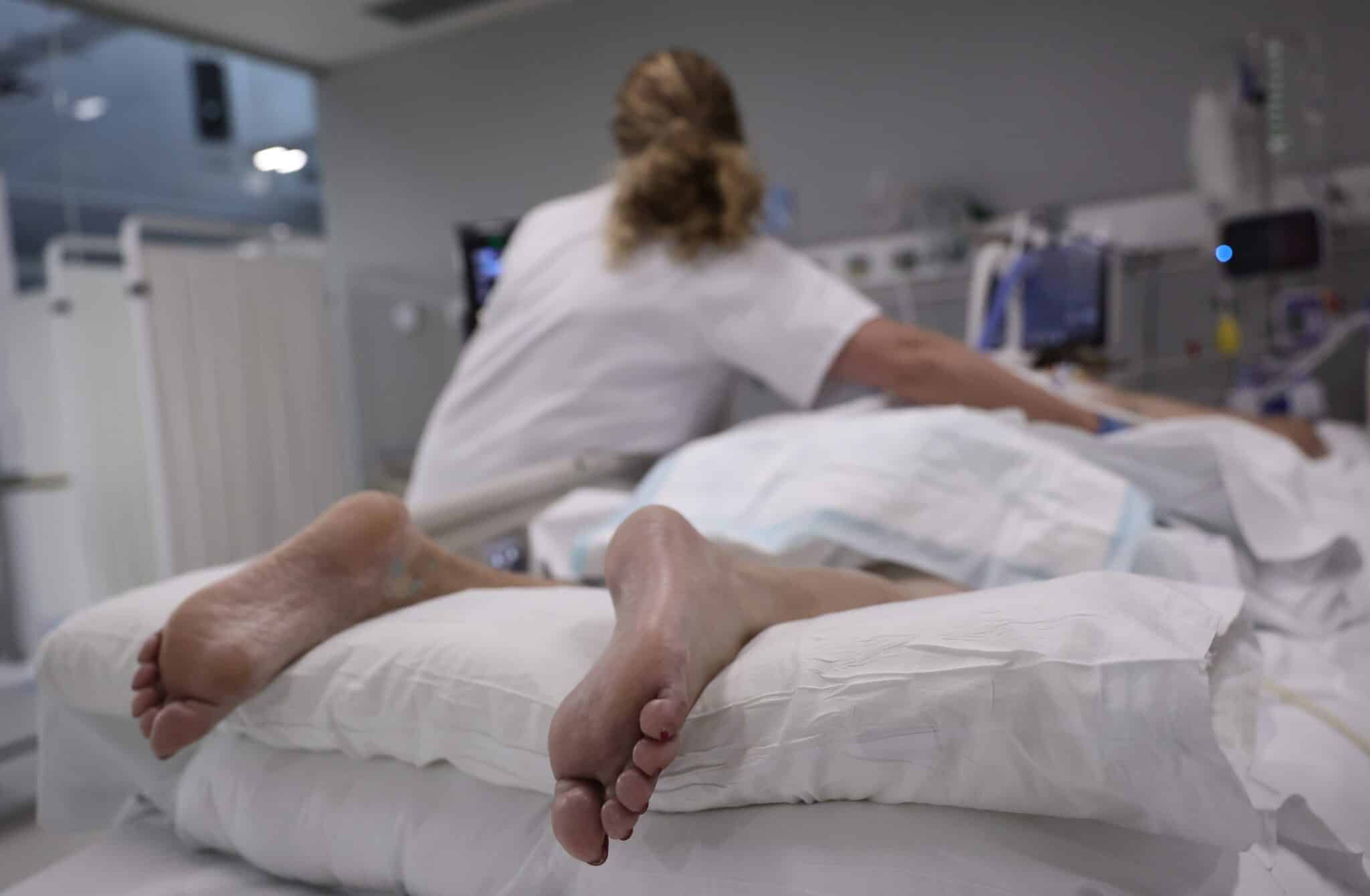 Una enfermera realiza una ecografía a una paciente recostada boca abajo en la UCI del Hospital Enfermera Isabel Zendal.