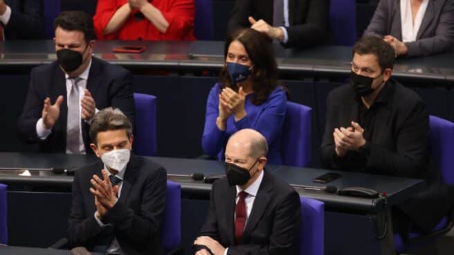 Olaf Scholz, con mascarilla negra, recibe el aplauso de los diputados alemanes en el Bundestag