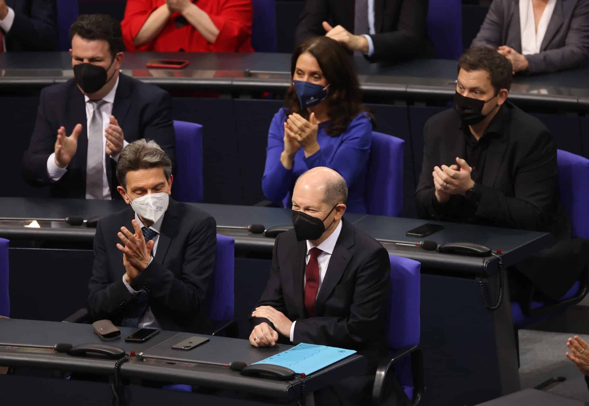 Olaf Scholz, con mascarilla negra, recibe el aplauso de los diputados alemanes en el Bundestag