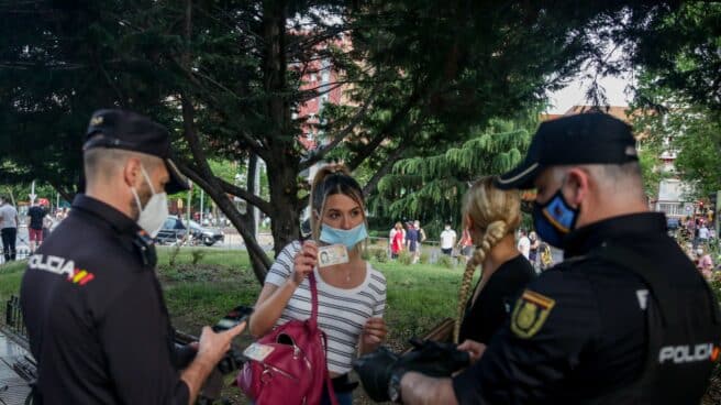 Dos policías nacionales identifican a una joven al inicio de la pandemia en Alcorcón (Madrid).