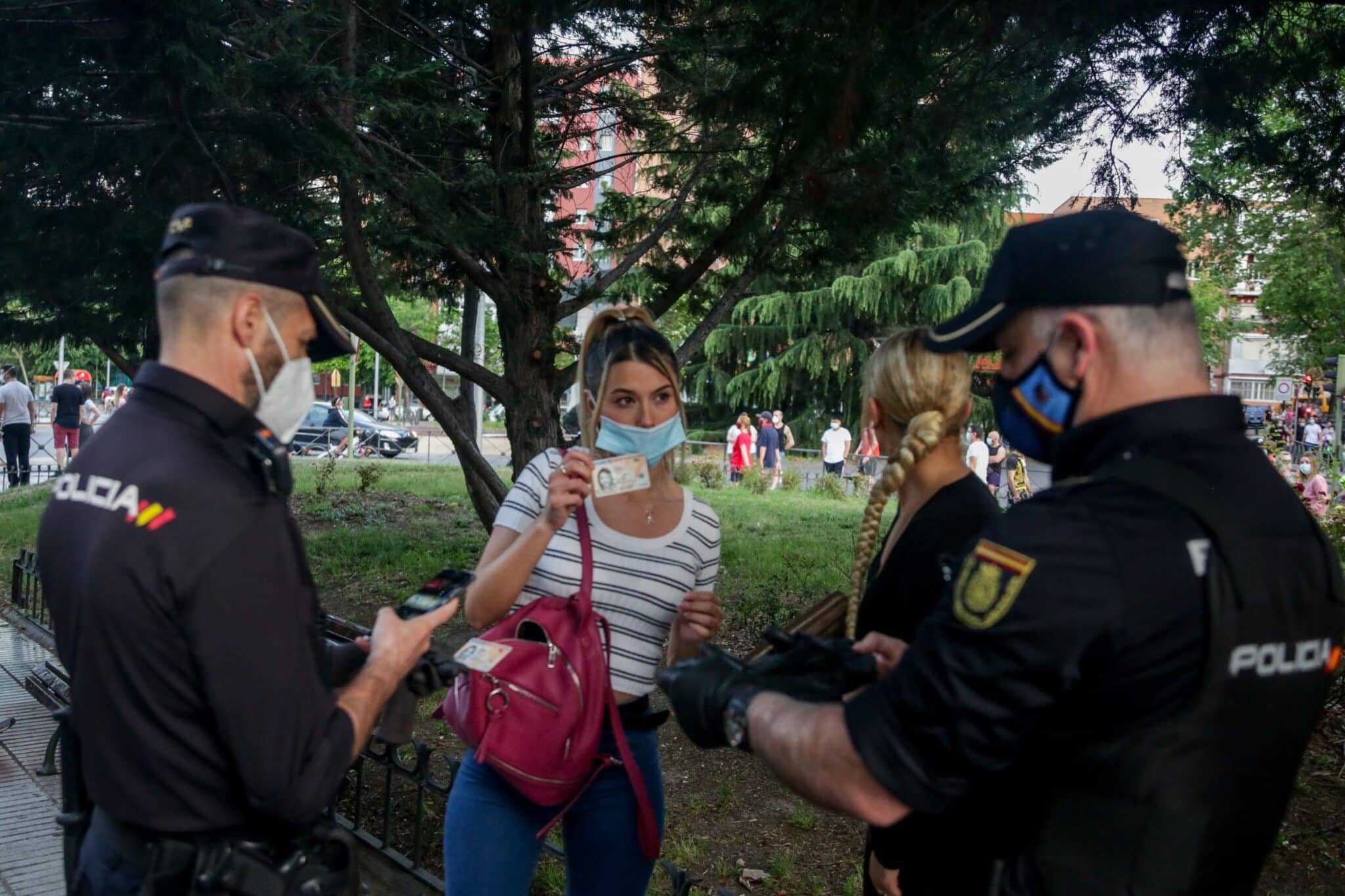 Dos policías nacionales identifican a una joven al inicio de la pandemia en Alcorcón (Madrid).