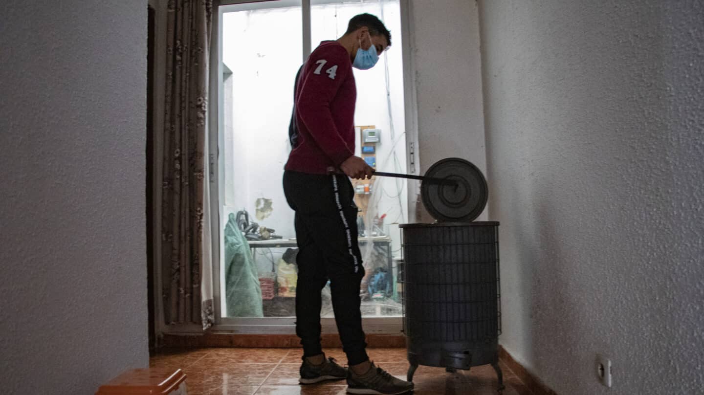 Hassan, un marroquí que vive en el sector 6 de la Cañada Real, abre la chimenea con la que calientan su casa ante la falta de luz y gas