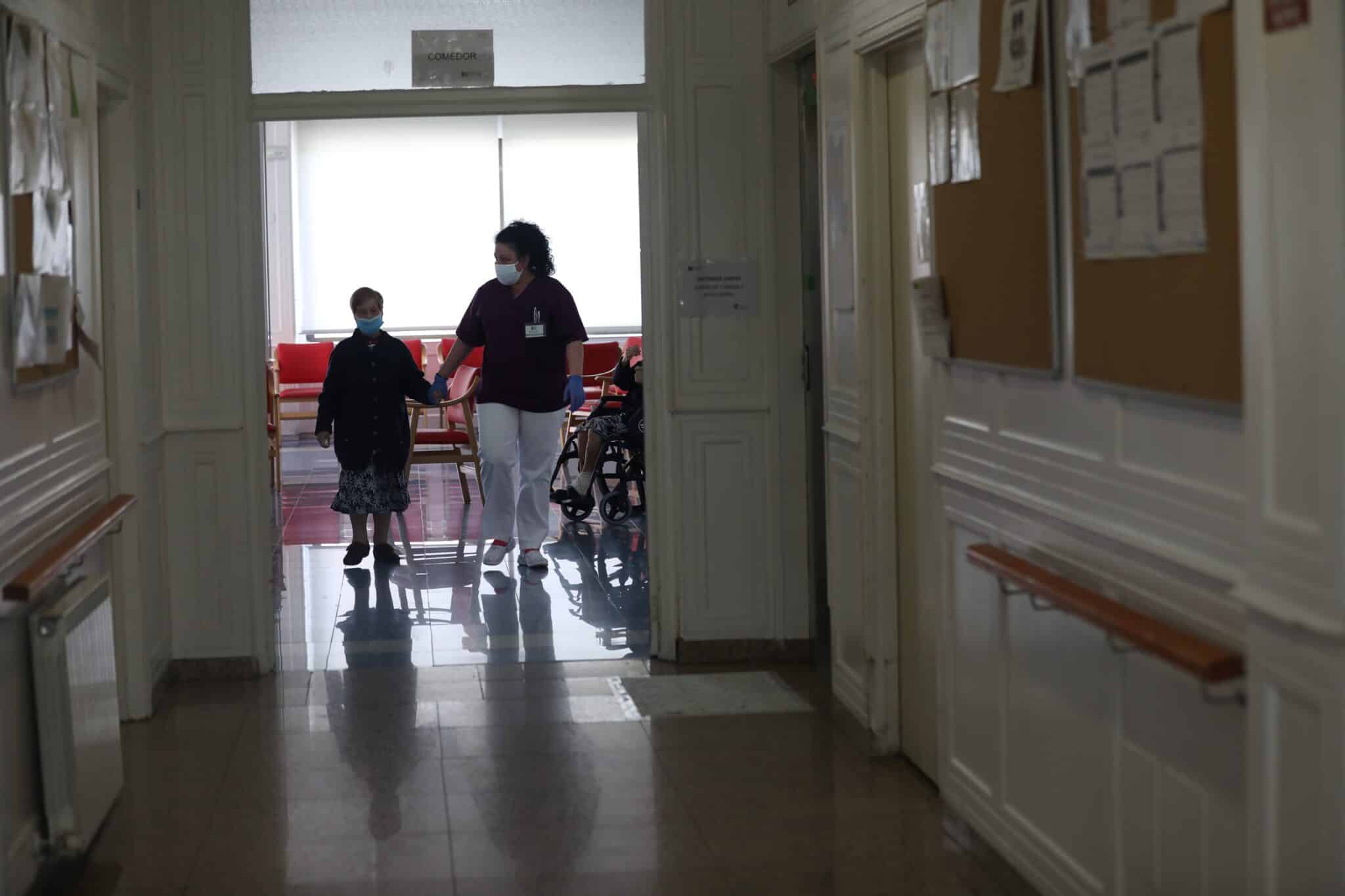 Una gerocultura coge de la mano a una residente en una residencia de Madrid.