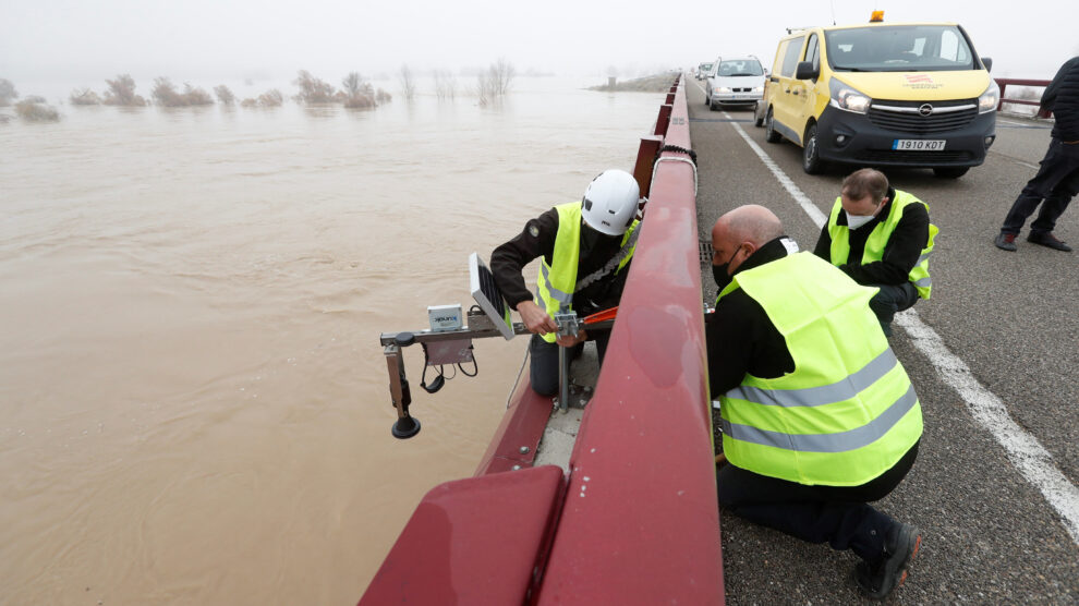 Operarios del Gobierno de Aragón colocan una dispositivo medidor sobre el cauce del rio Ebro