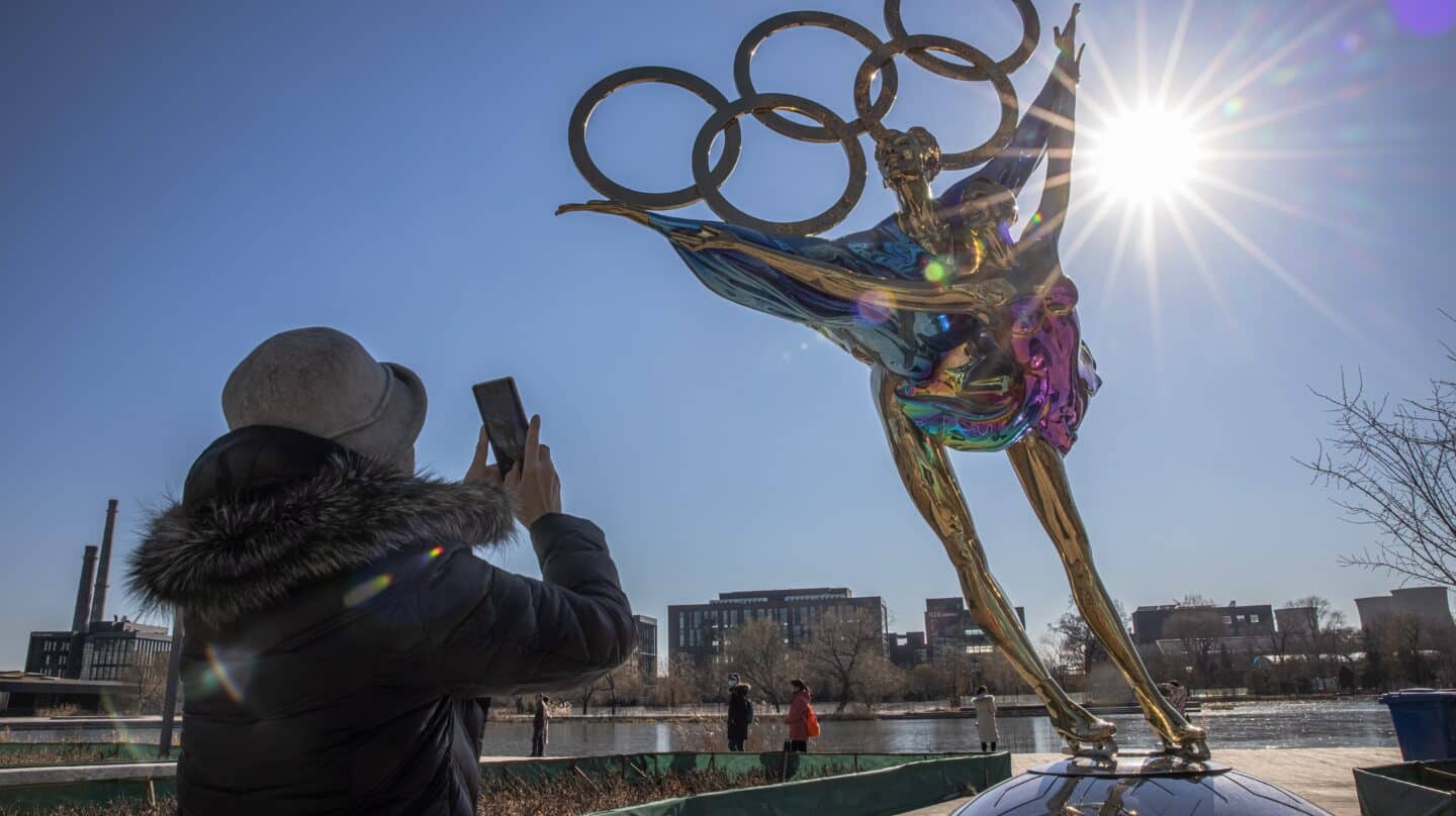 Una mujer se saca una foto delante delante de los anillos olímpicos en Pekín