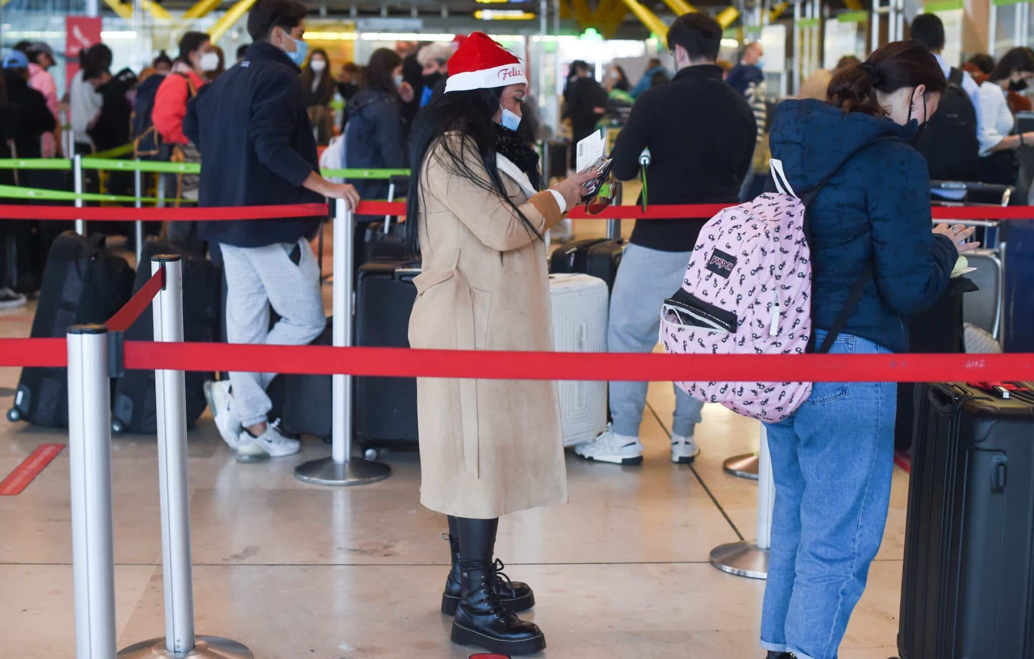 Una mujer con un gorro de Papá Noel hace cola en el aeropuerto de Barajas, este jueves 23 de diciembre.