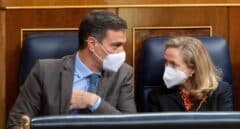 Pedro Sánchez y la vicepresidenta Nadia Calviño hablan en sus escaños del Congreso.