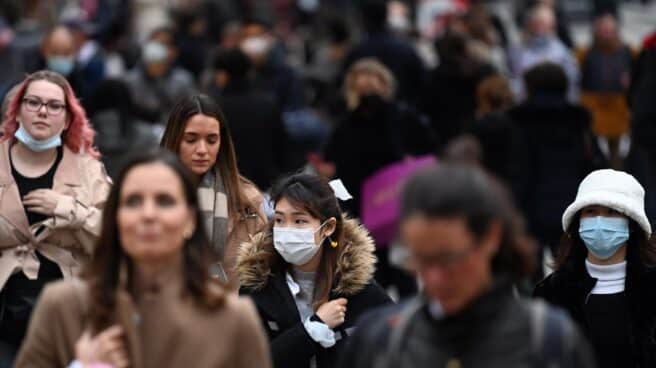 La variante ómicron amenaza por su mayor contagiosidad y menor período de incubación. Personas caminan por la calle con y sin mascarilla, ante la expansión de la variante ómicron.