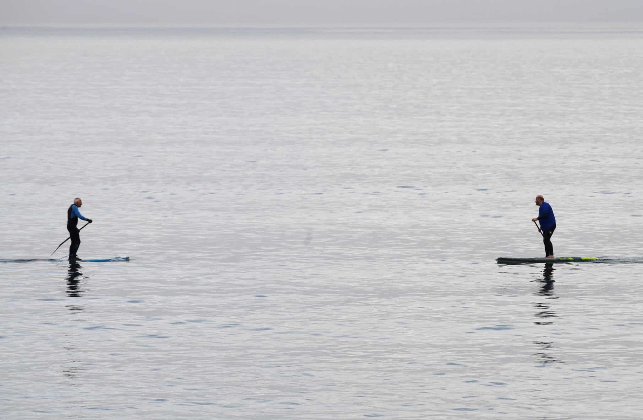 Dos aficionados al paddle surf practican en la playa de El Berrón, Asturias, este sábado, primer día del año.