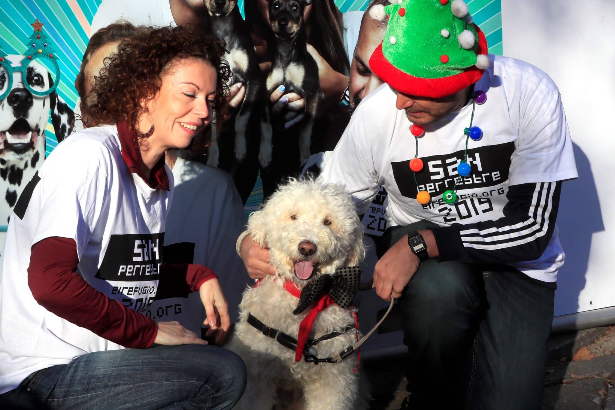 Una mascota posa junto a sus dueños este lunes en Madrid en el marco de la tradicional "Sanperrestre", una carrera 'perruna' que reivindica la necesidad de adoptar, proteger y cuidar a los animales y también de disfrutar junto a ellos.