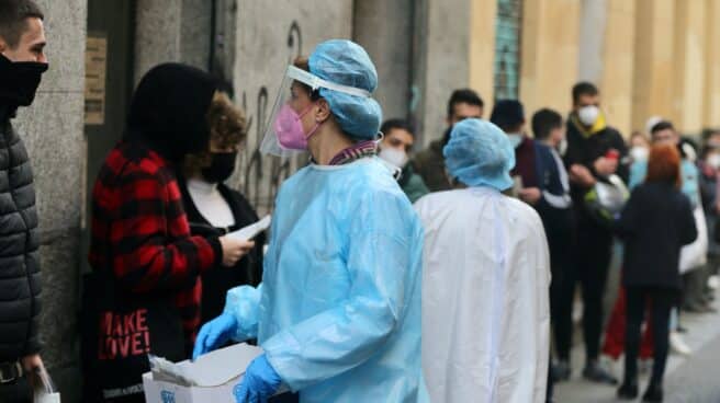 Una sanitaria recoge test de Covid-19 de las personas que hacen cola en el Centro de Salud Universidad