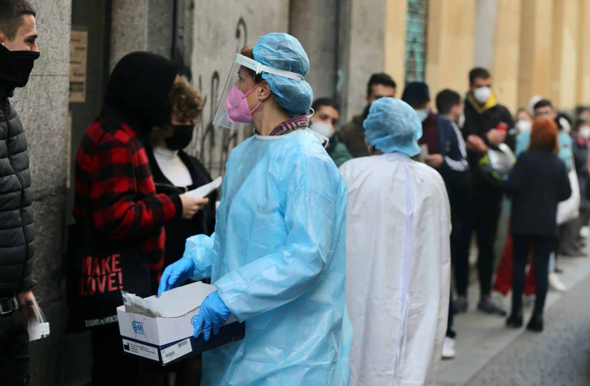 Una sanitaria recoge test de Covid-19 de las personas que hacen cola en el Centro de Salud Universidad