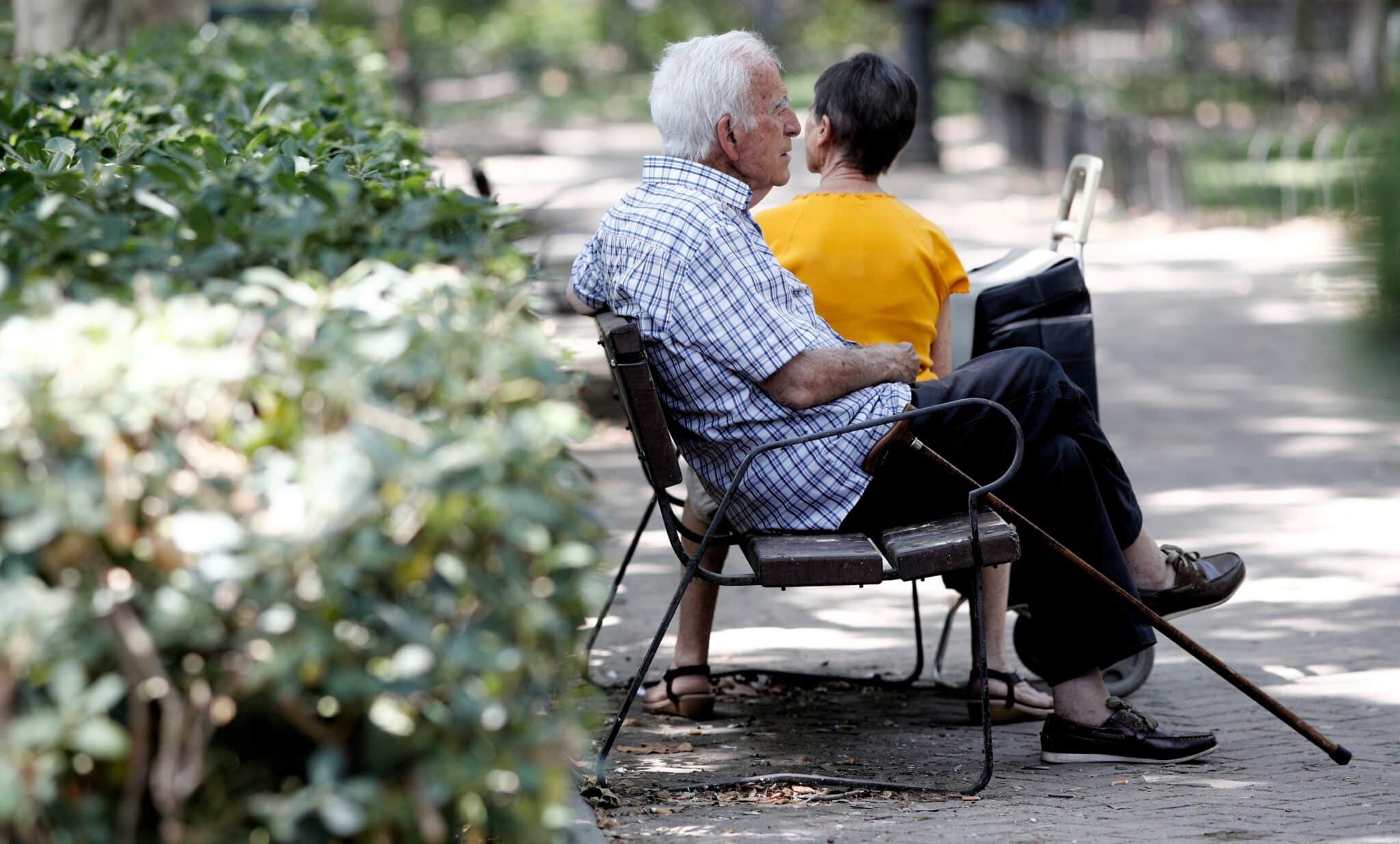 Un pensionista descansa en un banco de un parque de Madrid.