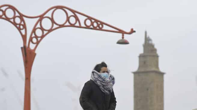Una persona camina protegida del frío en el Paseo Marítimo, el mismo día del paso de la borrasca Justine convertida en ciclogénesis explosiva en A Coruña, Galicia (España)