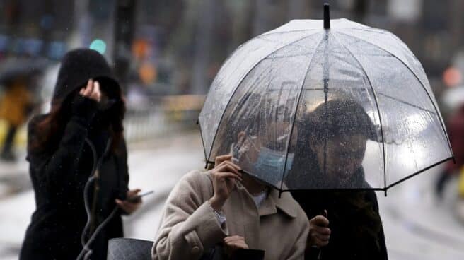 Peatones se protegen de la lluvia en Finlandia