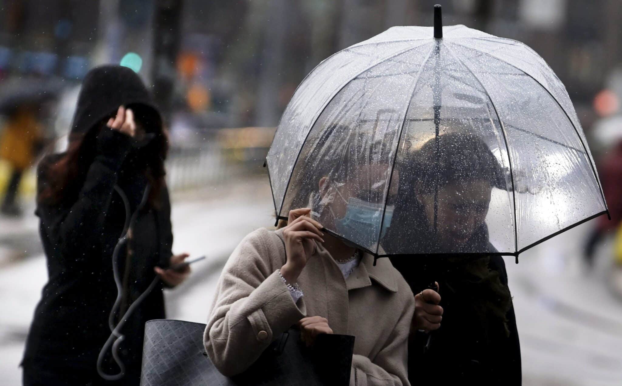 Peatones se protegen de la lluvia en Finlandia