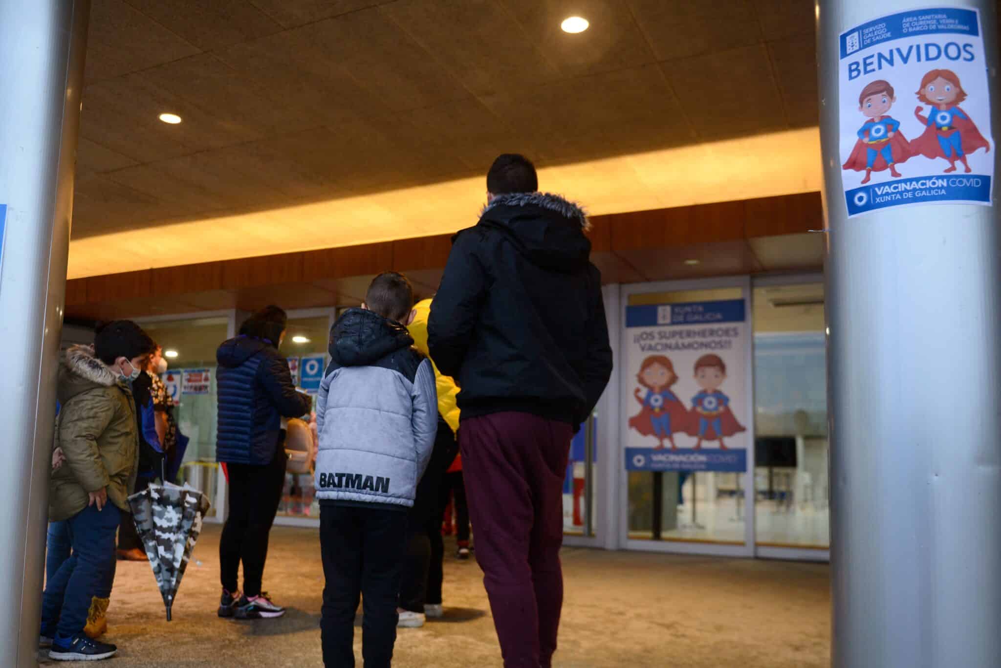 Varios niños acompañados de sus padres, a su llegada al recinto ferial Expourense para ser vacunados de Covid.