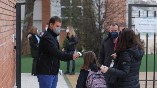 Vuelta a las aulas tras Navidad en Madrid Un trabajador toma la temperatura a un niño a su llegada al primer día de clase presencial tras la Navidad