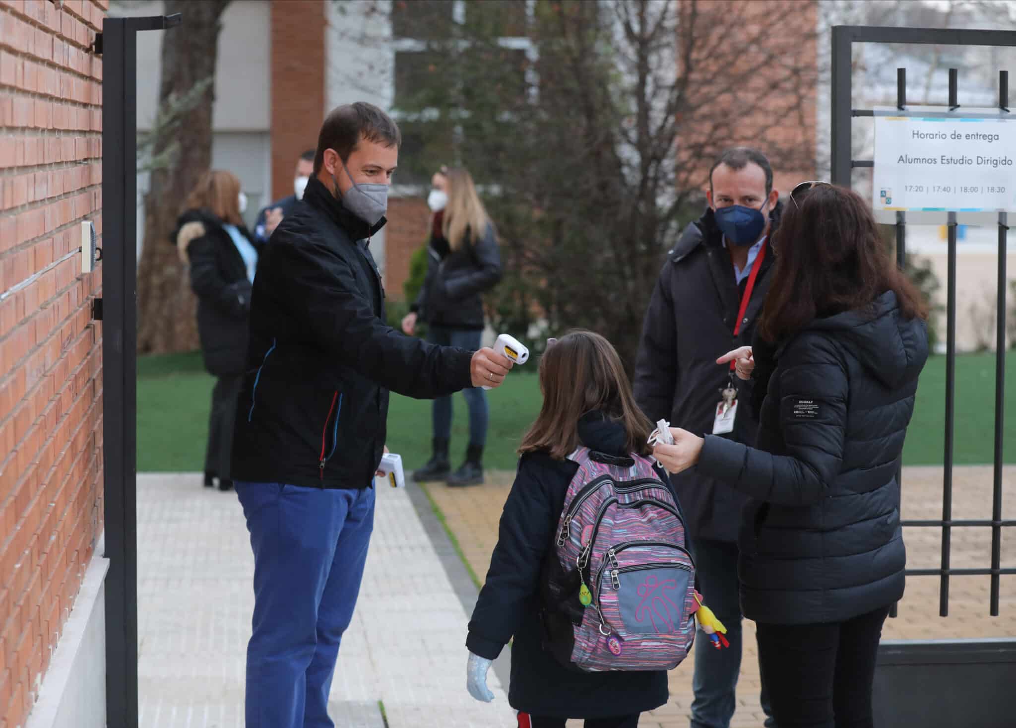 Un trabajador toma la temperatura a un niño a su llegada al primer día de clase presencial tras la Navidad