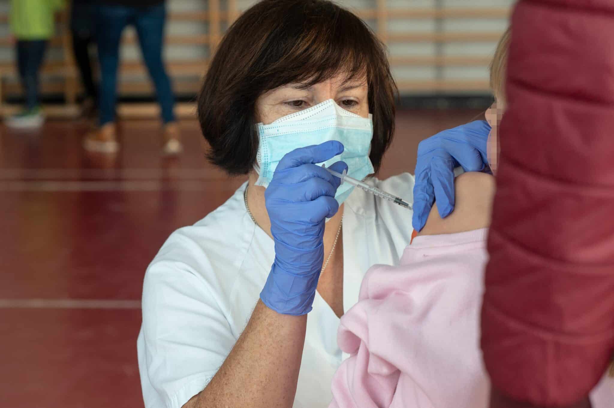 Una niña recibe la vacuna contra el Covid-19, en el CEIP Manel García Grau, a 13 de enero de 2022, en Castellón de la Plana