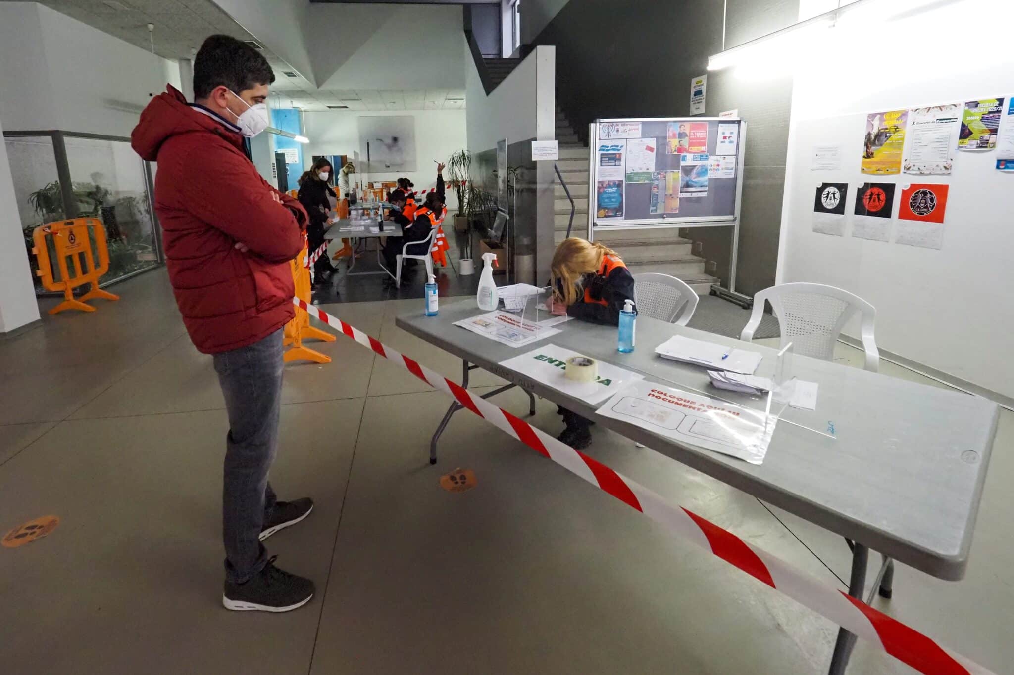 Un paciente da su documentación para realizarse uno de los tests de antígenos en un polideportivo de Valladolid.