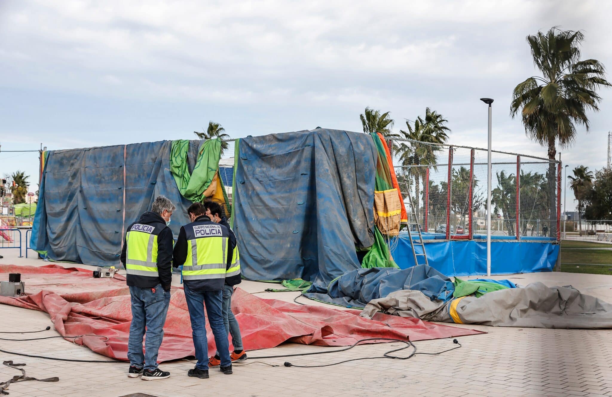 Agentes de la policía nacional investigan la atracción hinchable donde ha fallecido una menor, en la feria de Mislata