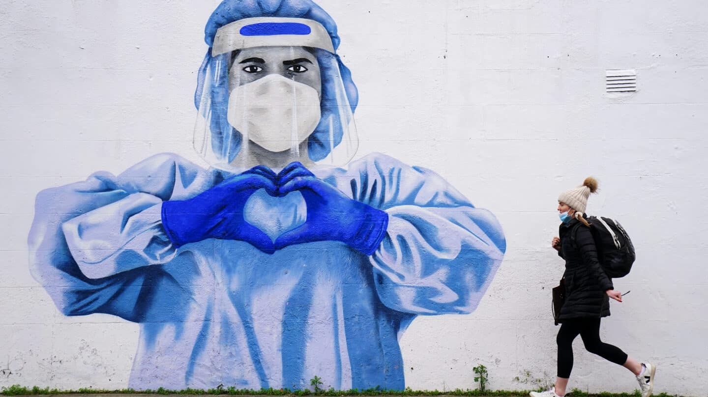 Una mujer pasea por Dublín (Irlanda), frente a un mural dedicado a los sanitarios en la pandemia.