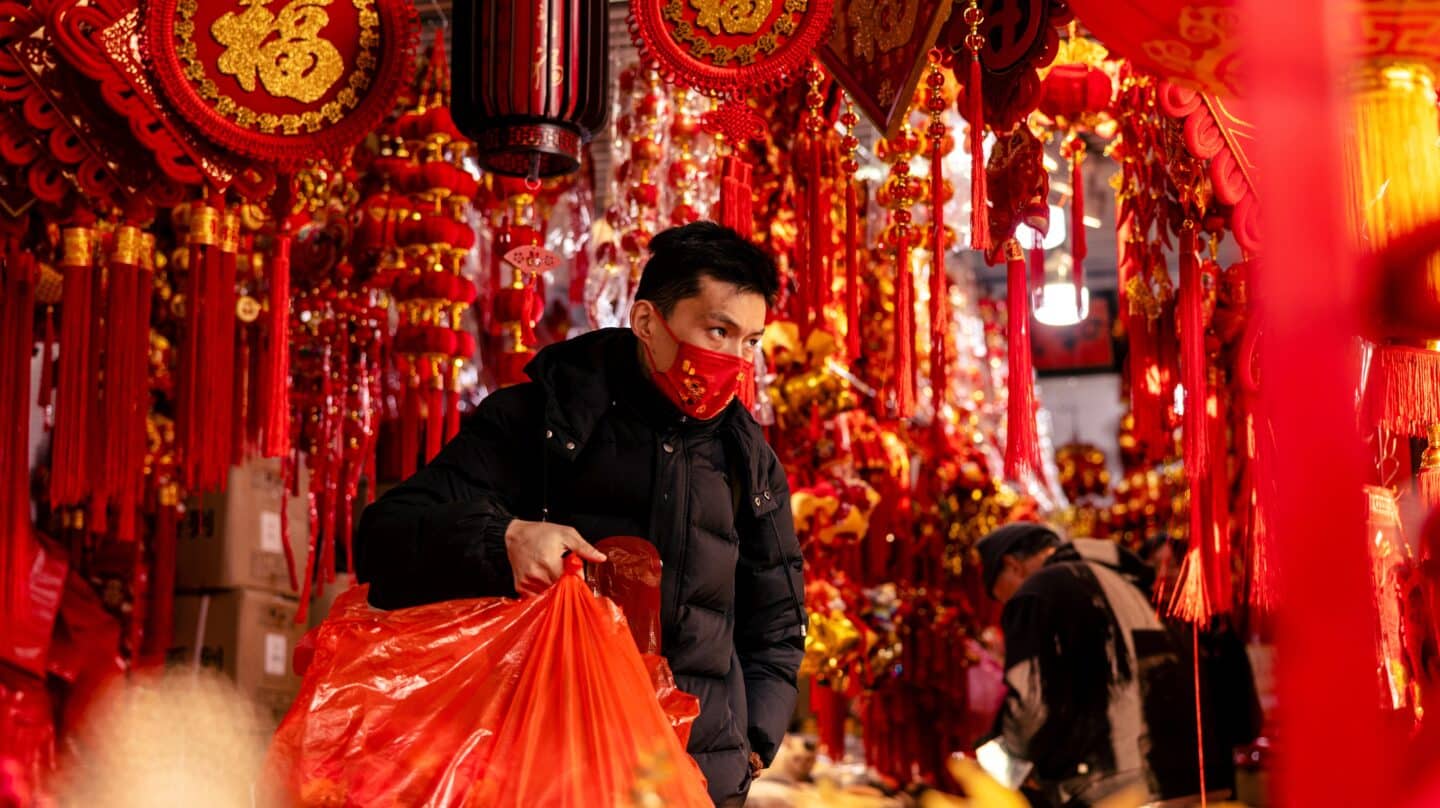 Un hombre compra decoraciones para el año nuevo chino en un mercado de Shanghai, China.