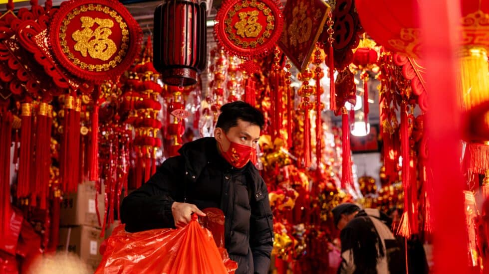 Un hombre compra decoraciones para el año nuevo chino en un mercado de Shanghai, China.