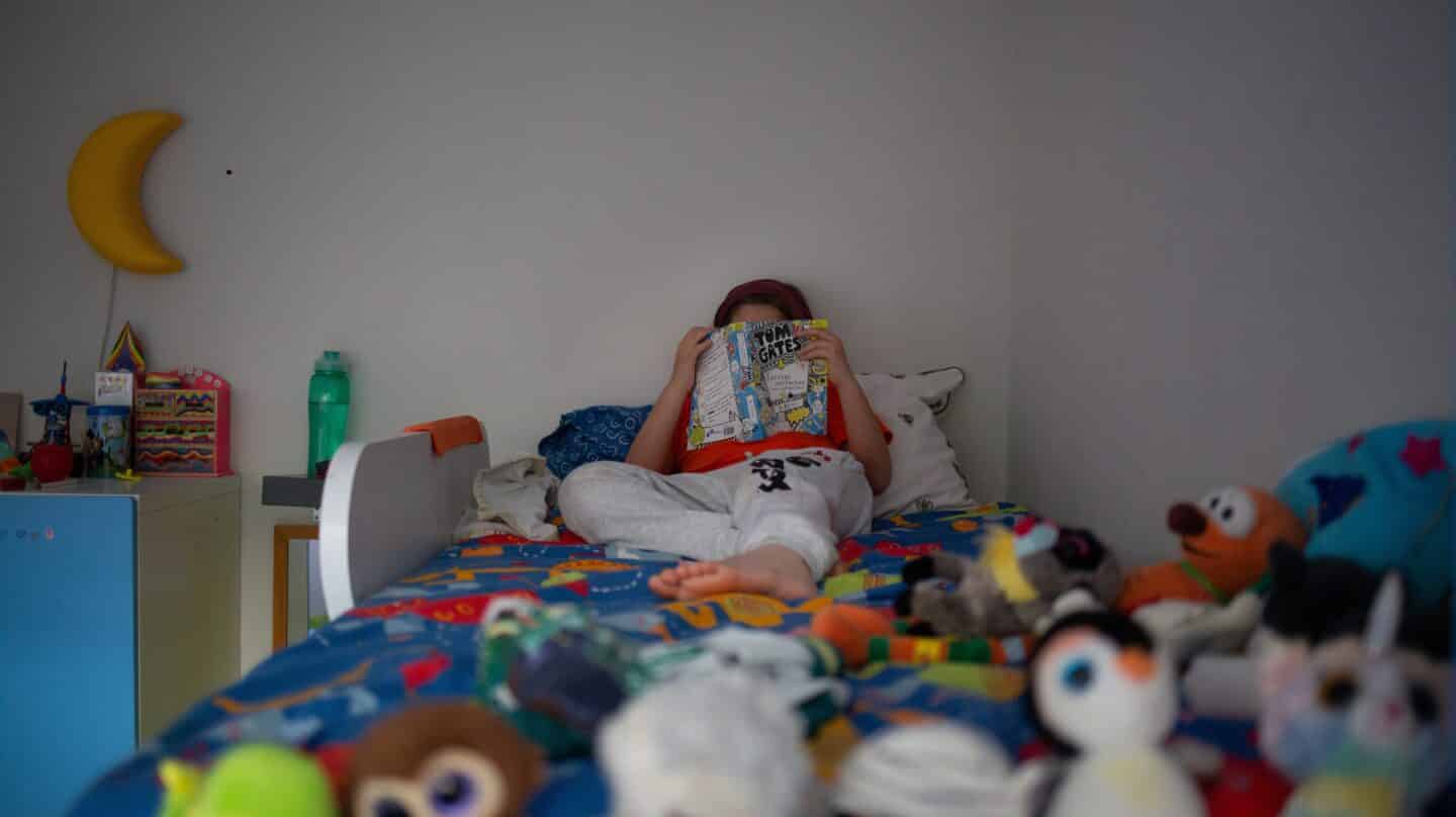 Una niña lee en su domicilio durante el confinamiento estricto de la pandemia.