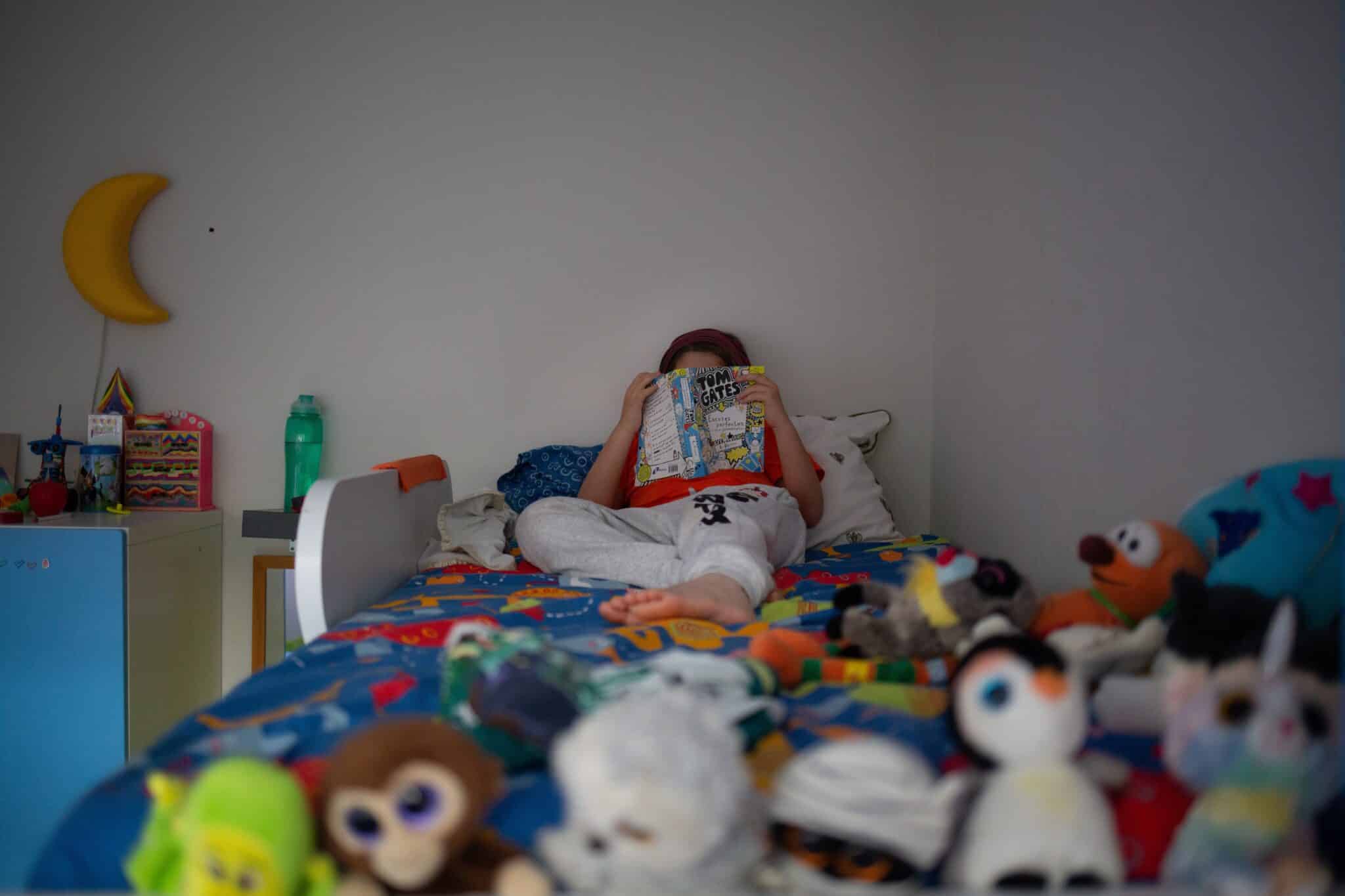 Una niña lee en su domicilio durante el confinamiento estricto de la pandemia.