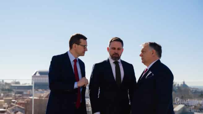 El presidente de Vox, Santiago Abascal, conversa con el primer ministro polaco Mateusz Morawiecki (i) y el húngaro Viktor Orban (d), en Madrid.