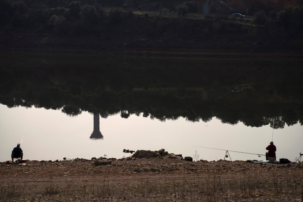 Dos personas pescan en el embalse de El Vicario, 