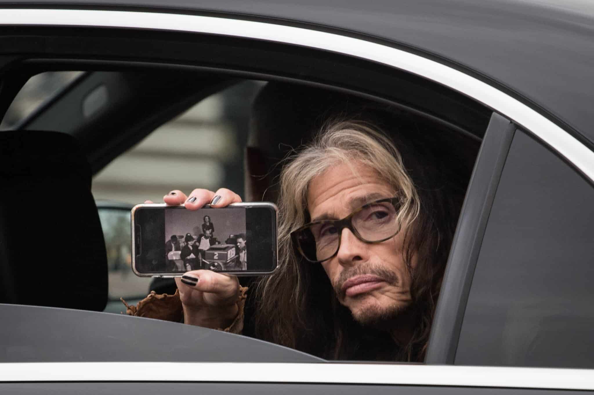 Steve Tyler, cantante estadounidense de la banda Aerosmith, se asoma por la ventana de un coche mientras pasa por el Palacio de Buckingham.