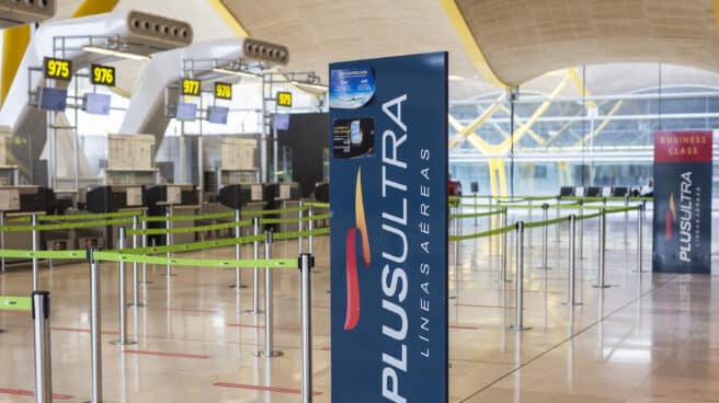 Un panel muestra información sobre vuelos de la aerolínea Plus Ultra en el aeropuerto de Madrid.